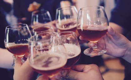 Stock image: people holding glasses of alcohol to 'cheers'